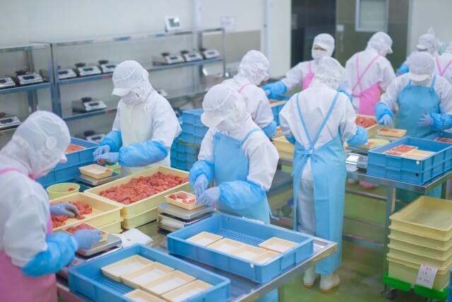 工場内で食品の製造・加工をしている人たち