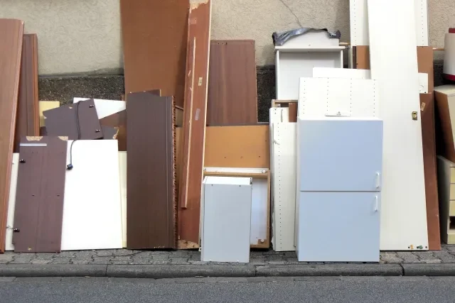 家具やベッドなどの粗大ゴミが家の外に置かれている様子